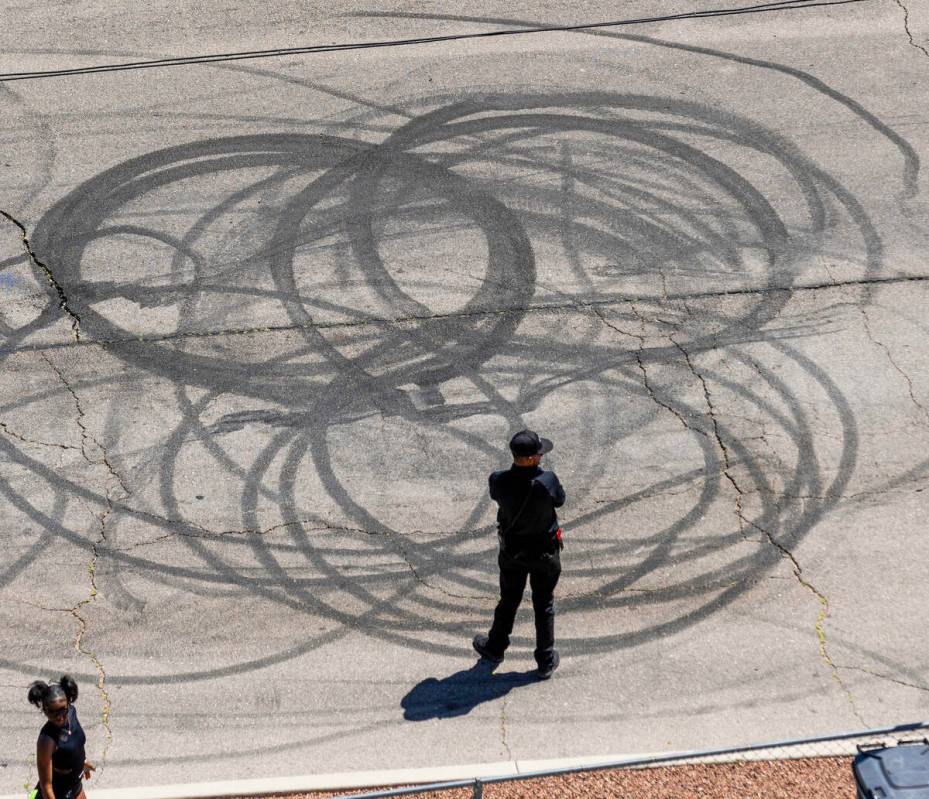 A man stands about a car burnout spot alongside the track during Day 2 of NHRA 4-Wide Nationals ...