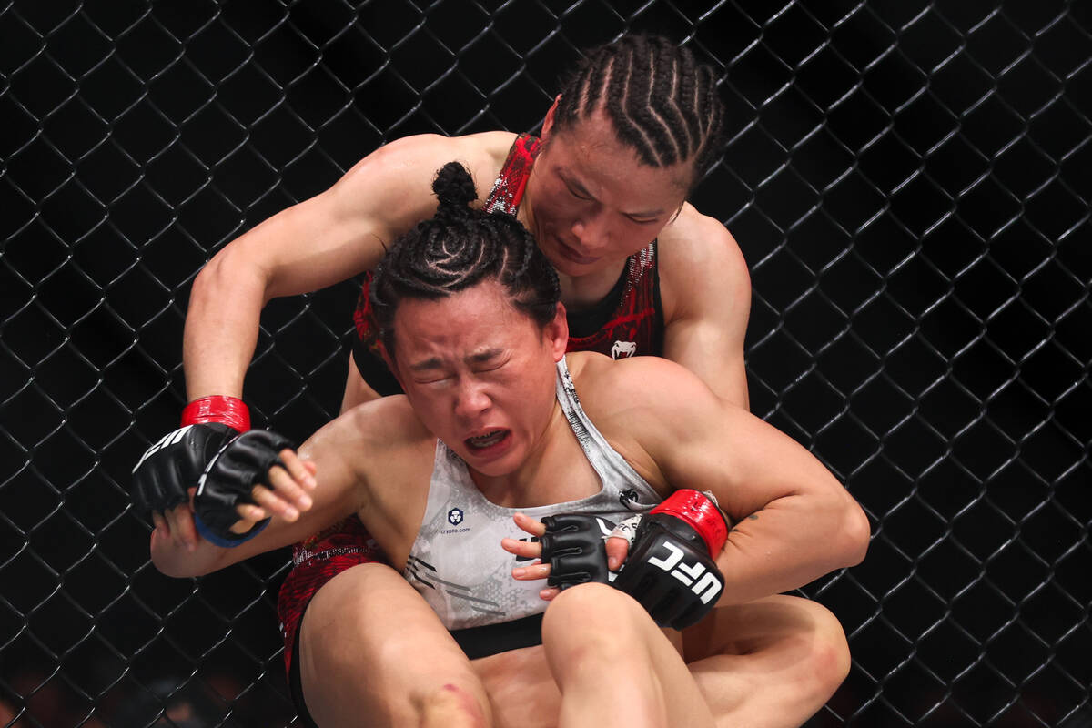 Weili Zhang, behind, takes Xiaonan Yan to the mat during a UFC 300 mixed martial arts women&#x2 ...
