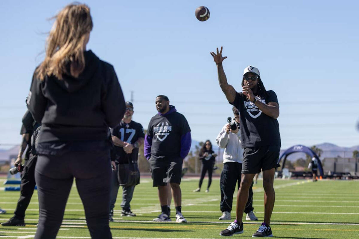 Raiders wide receiver Davante Adams makes a throw to a participant of his youth camp on Sunday, ...