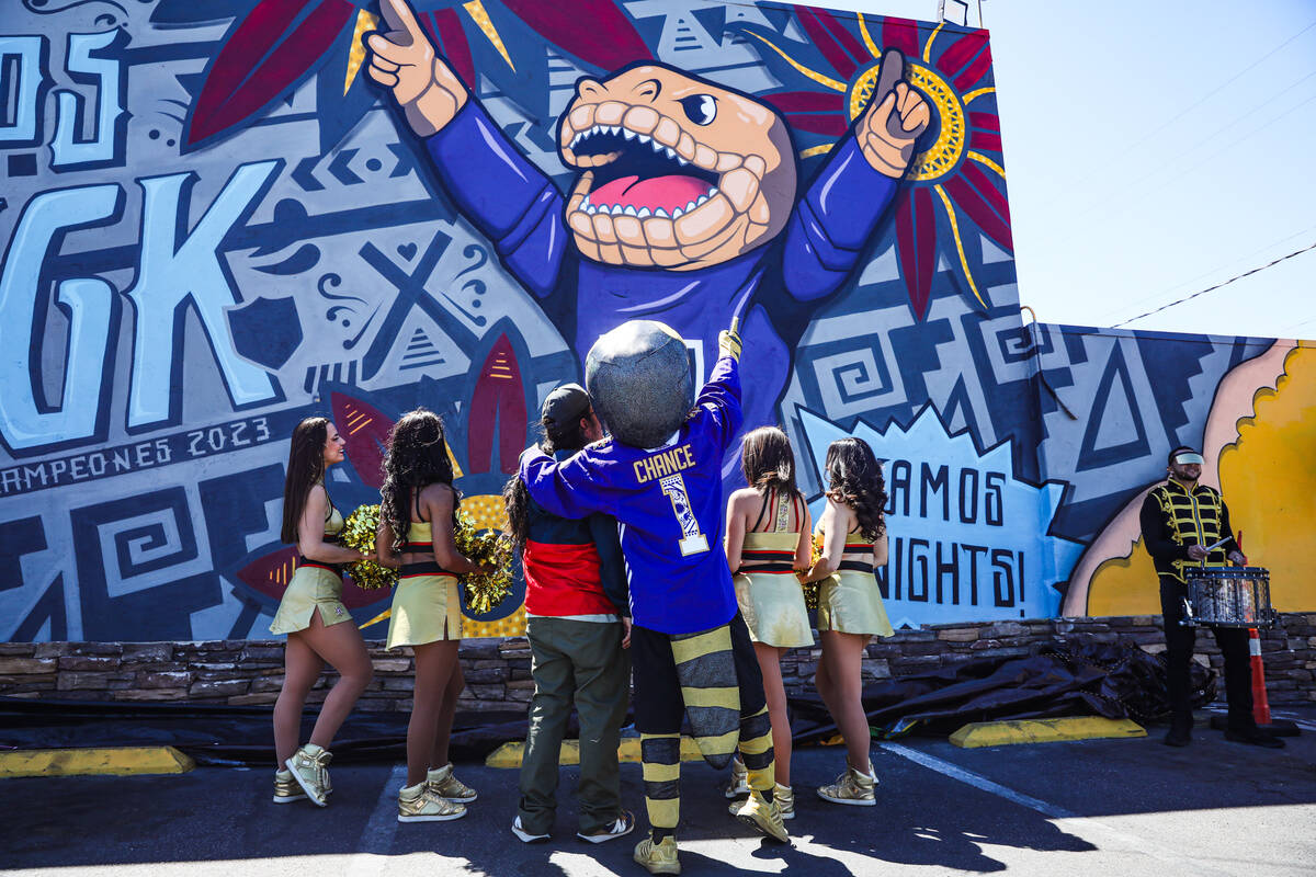 Golden Knights mascot Chance embraces mural artist Anthony Ortega as they view the Golden Knigh ...