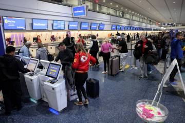 Travelers check their bags a Harry Reid International Airport on Monday, Feb. 12, 2024, a day a ...