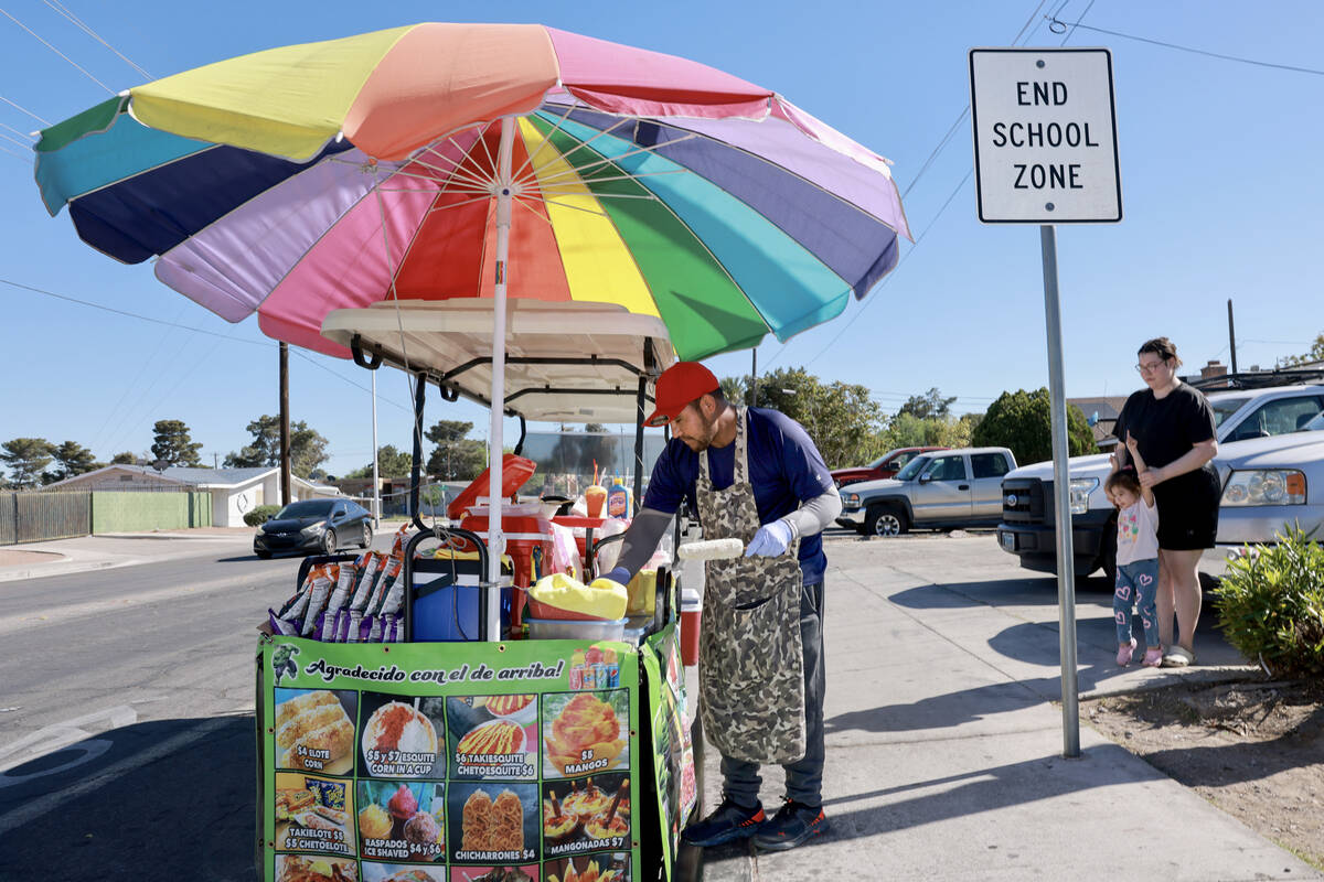 Sidewalk vendor Oracio Gonzalez Moreno prepares orders for customers in Las Vegas Tuesday, Apri ...