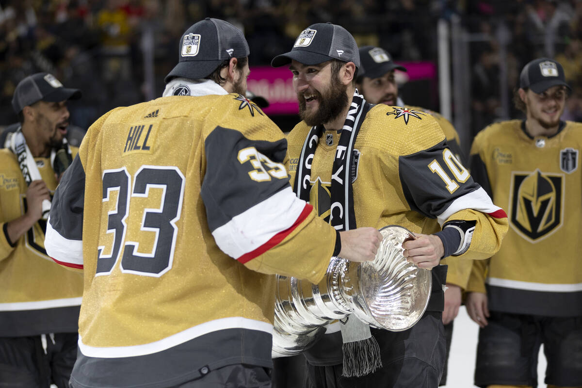 Golden Knights goaltender Adin Hill (33) hands off the Stanley Cup to center Nicolas Roy (10) a ...