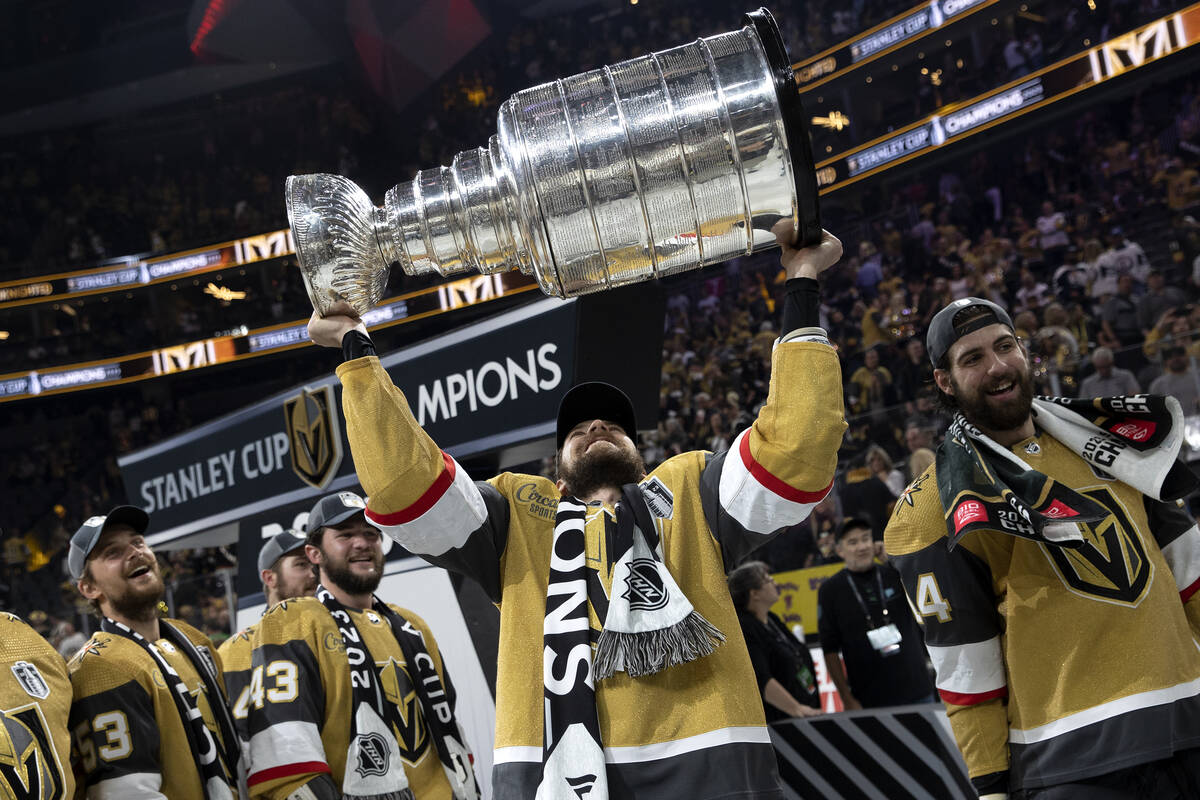 Golden Knights defenseman Shea Theodore (27) celebrates with the Stanley Cup after winning the ...
