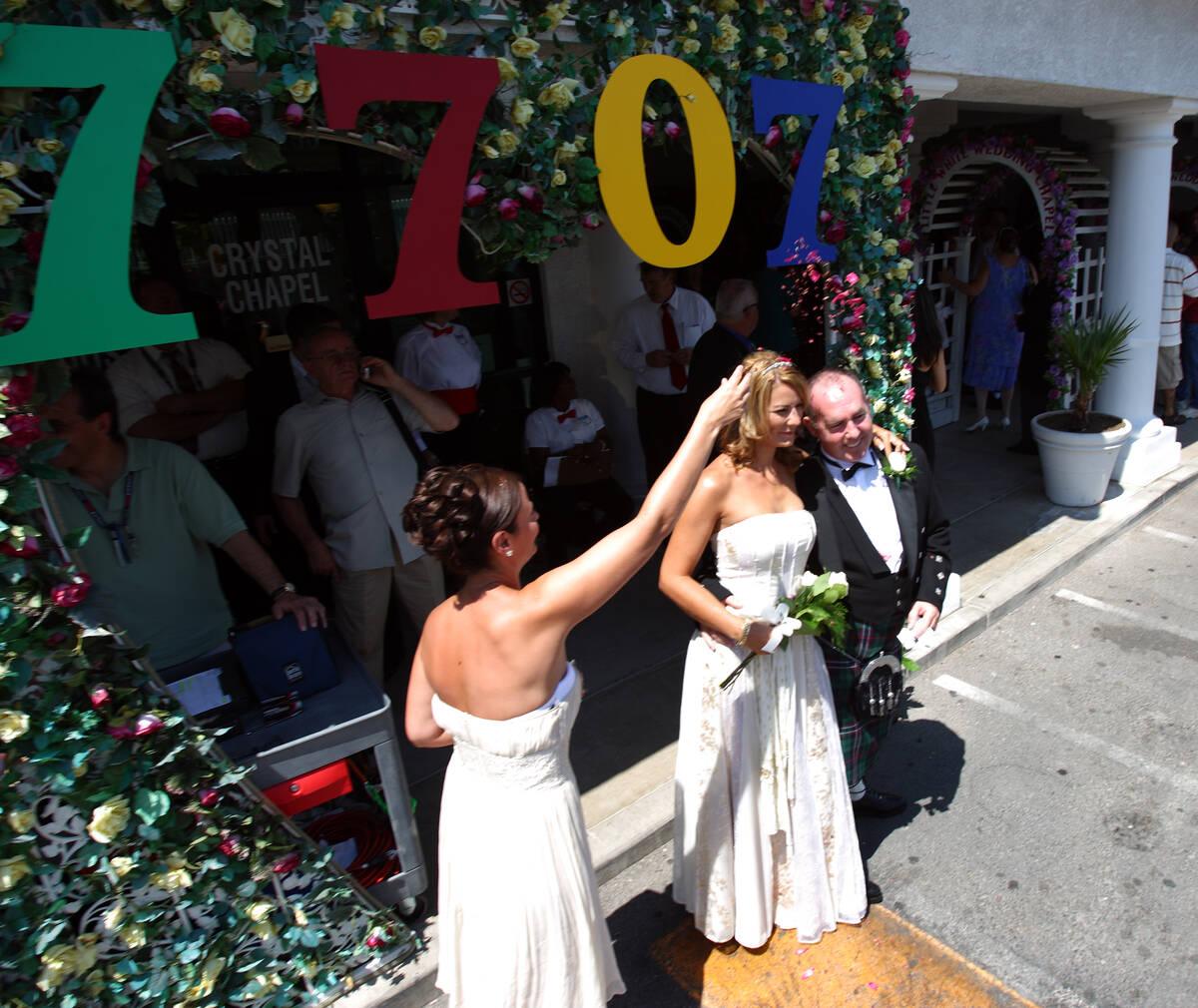 Bridesmaid Anne Davie, left, tosses flower petals on newlyweds Suzanne and Stephen Reid of Ayrs ...
