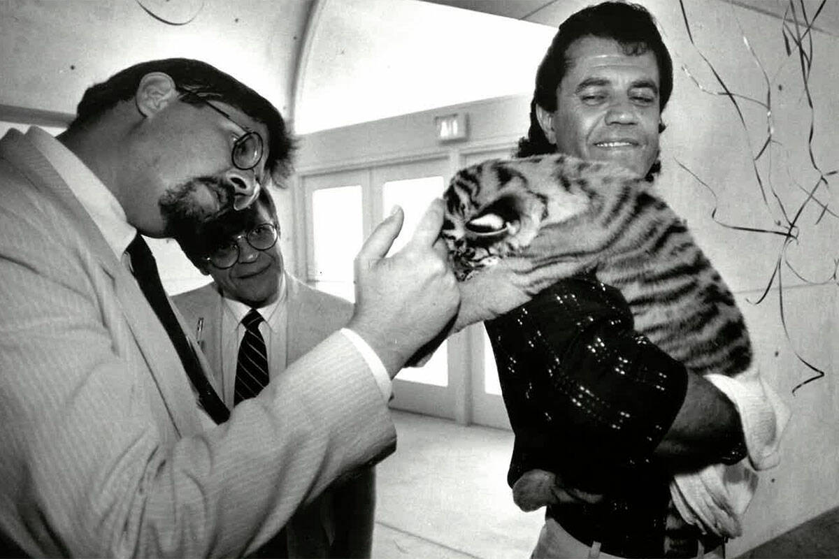 Gary Ogren pets 4 year old tiger cub Samantha, held by Jonathan Kraft on the opening day of the ...