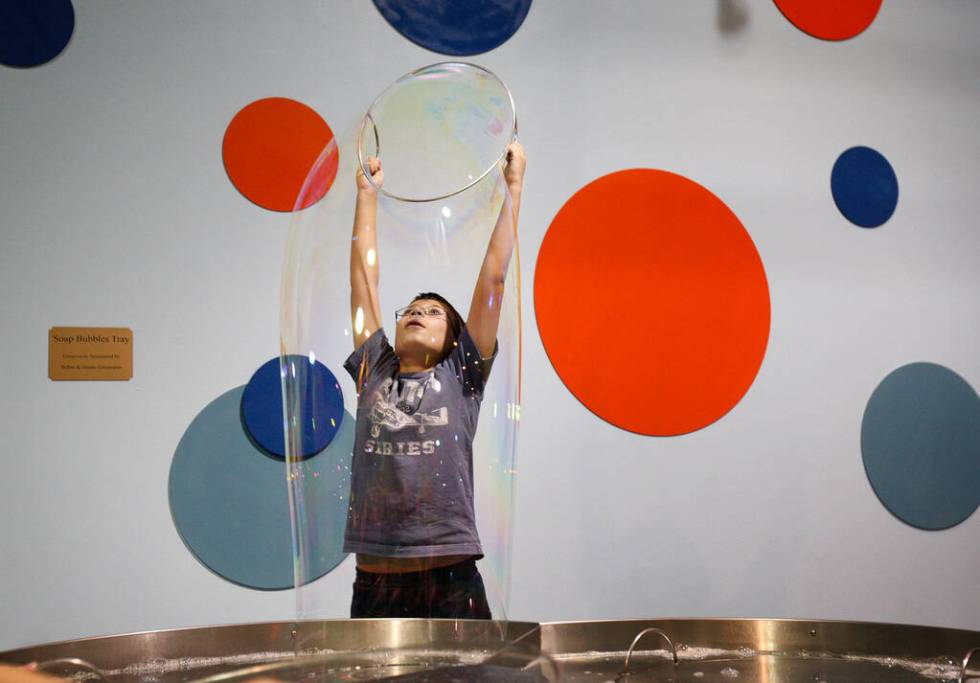 Ten-year-old Will Hall makes a large bubble at the Soap Bubbles Tray in the Lied Discovery Chil ...
