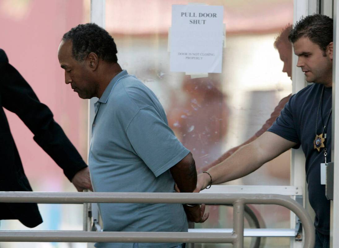 In this Sept. 16, 2007 file photo, O.J. Simpson is taken from the Las Vegas Police Investigativ ...