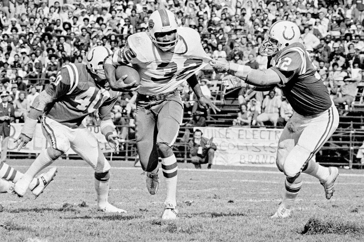 Buffalo Bills running back O.J. Simpson (32) has his jersey pulled by Baltimore Colts linebacke ...