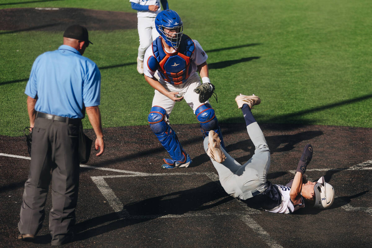 Shadow Ridge pitcher Benjamin Moss (4) falls after being tagged out by Bishop Gorman catcher Bu ...