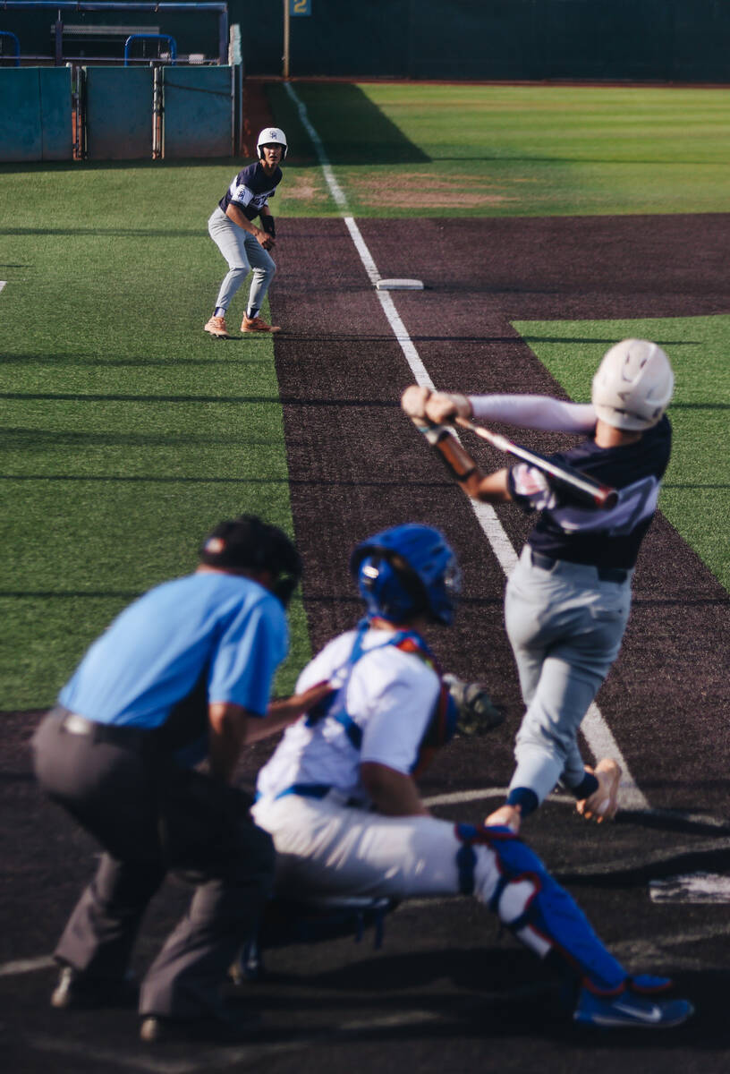A Shadow Ridge teammate eyes his teammate as he swings the bat during an baseball game between ...