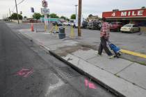 A pedestrian walks past the scene on Boulder Highway near Sahara Avenue Thursday, April 18, 202 ...