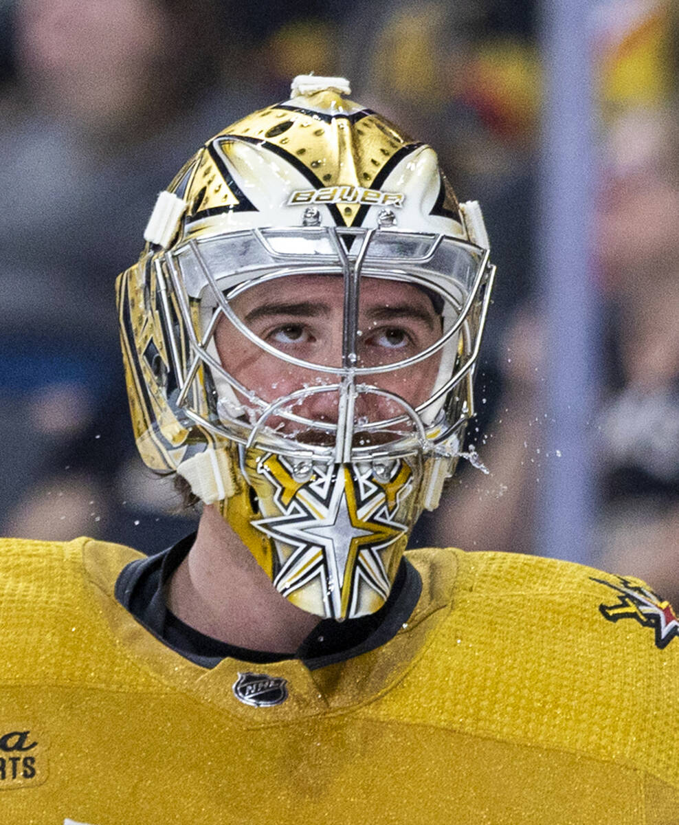 Golden Knights goaltender Logan Thompson (36) spits some water on a timeout against the Chicago ...