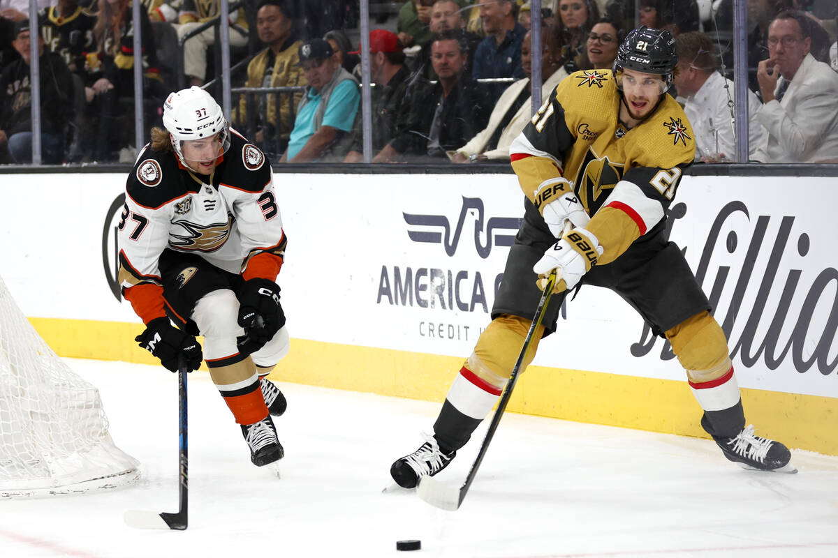 Golden Knights center Brett Howden (21) passes the puck with pressure from Ducks defenseman Wil ...