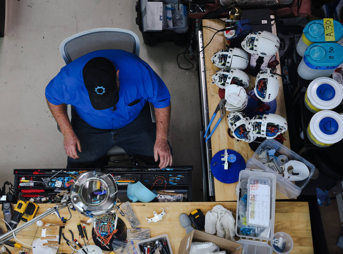 Tim Johns, head assembler, works on a robot head in the making at the workshop of Realbotix, a ...