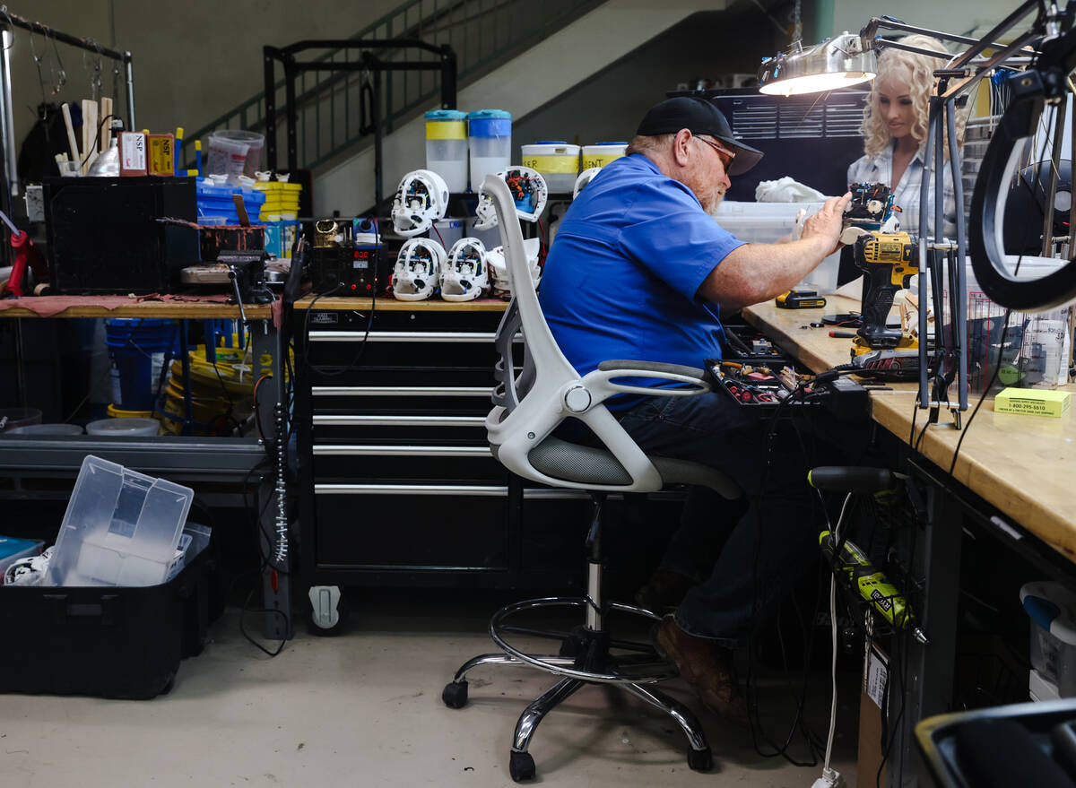 Tim Johns, head assembler, works on a robot head in the making at the workshop of Realbotix, a ...