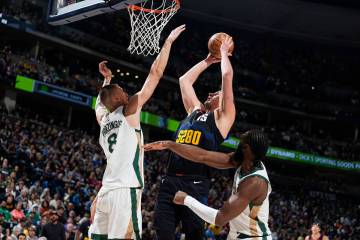 Denver Nuggets center Nikola Jokic (15) goes up for a basket Boston Celtics center Kristaps Por ...