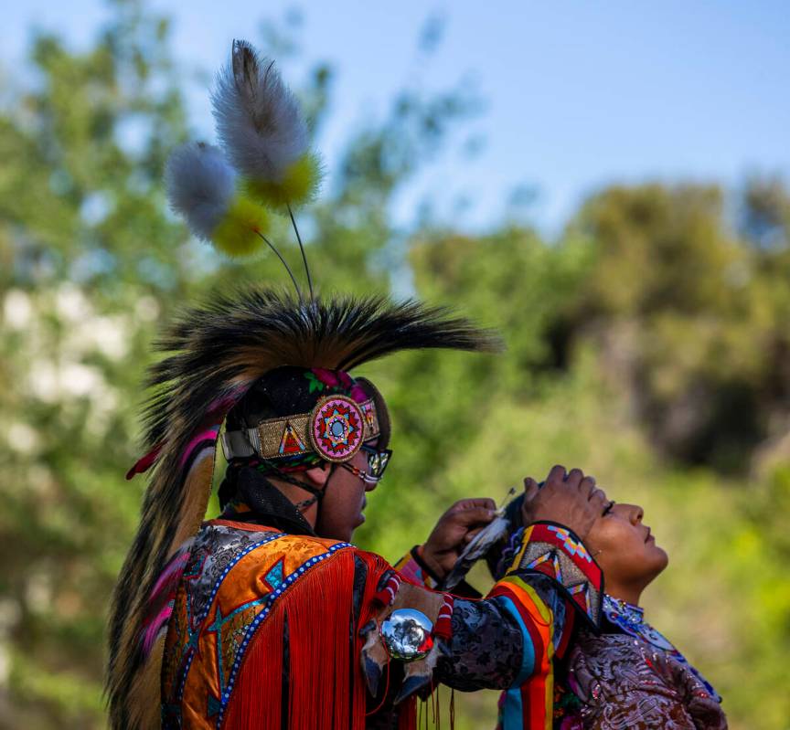 Sal Brown helps Myra Harrison with a feather in her hair, both with the Navajo tribe from Flags ...