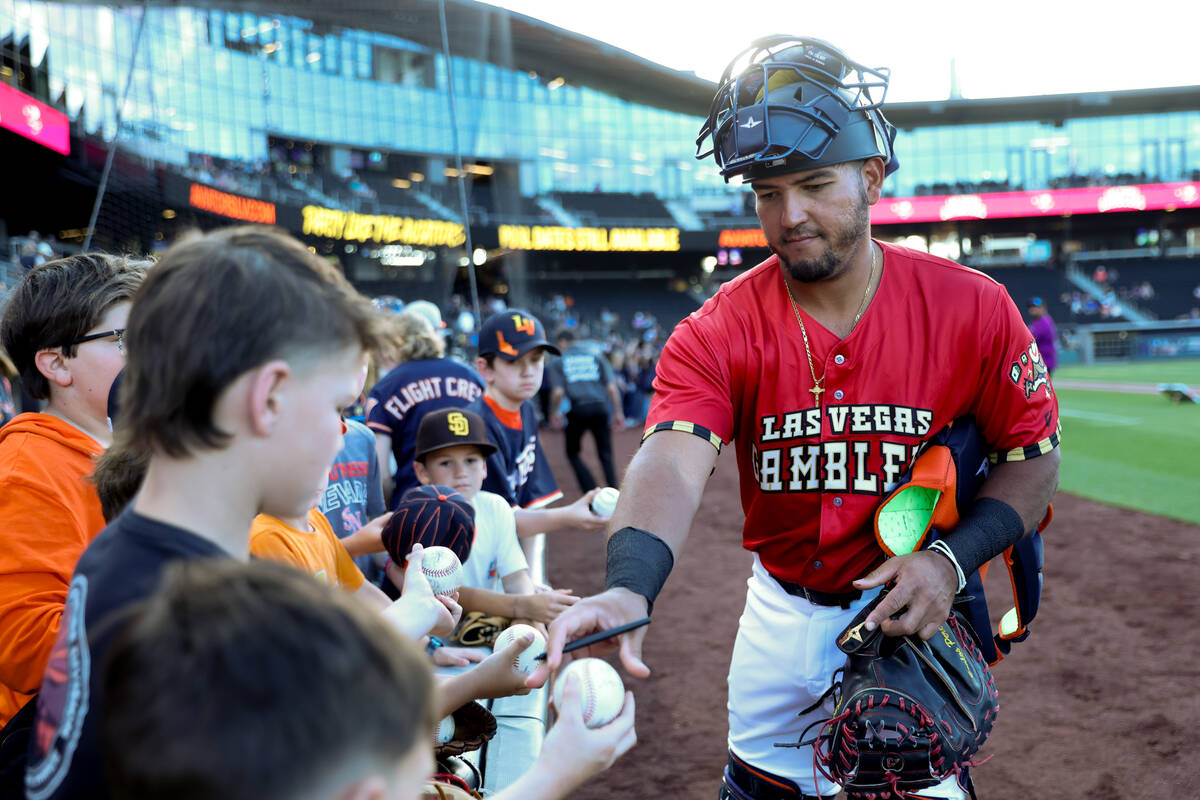 Las Vegas Aviators catcher Carlos Pérez, wearing a Las Vegas Gamblers jersey, signs autogr ...