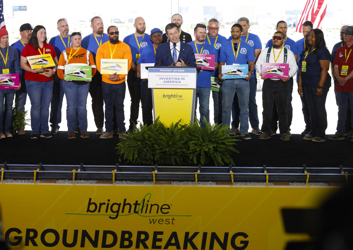 U.S. Department of Transportation Secretary Pete Buttigieg flanked by union workers speaks duri ...