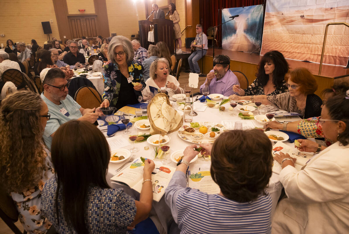 Karpas is dipped in saltwater during a Passover Seder meal at Congregation Ner Tamid on Monday, ...