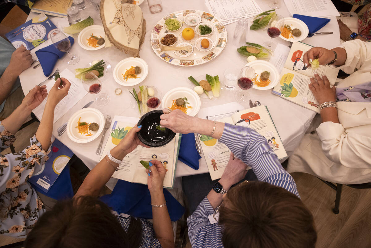 Karpas is dipped in saltwater during a Passover Seder meal at Congregation Ner Tamid on Monday, ...