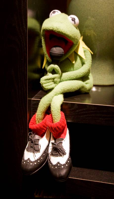 A Kermit the Frog puppet, wearing a version of Danny Gans' signature spectator shoes and red so ...