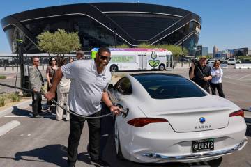 Raiders alumnus Napoleon McCallum demonstrates plugging in an electric vehicle during a press c ...