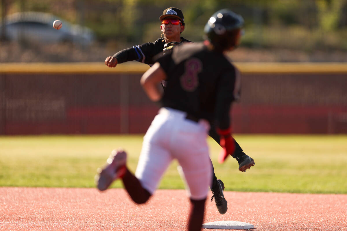 Basic shortstop Ty Southisene (3) throws to first base for a double play during a high school b ...