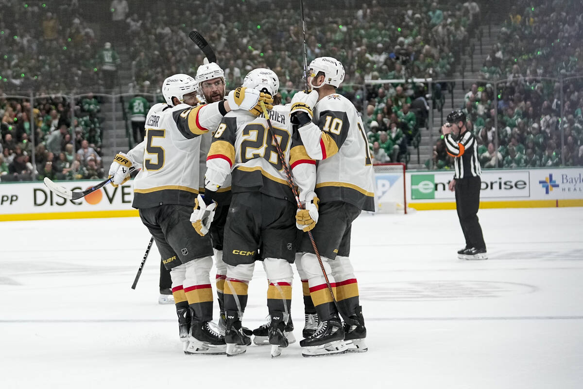 Vegas Golden Knights players surround Noah Hanifin after he scored against the Dallas Stars dur ...