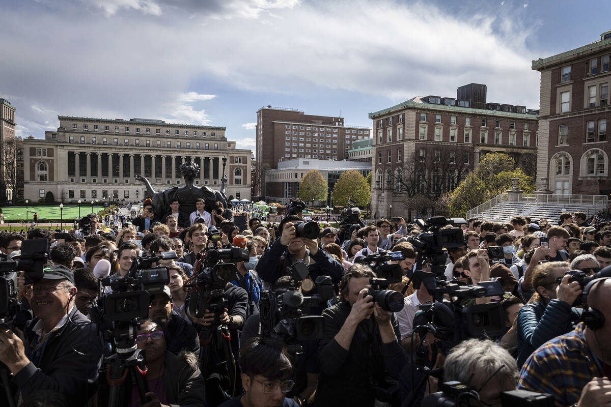 Students and press look on as Speaker of the House Mike Johnson, R-La., speaks to the media on ...