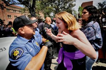 A University of Southern California protester, right, confronts a University Public Safety offi ...