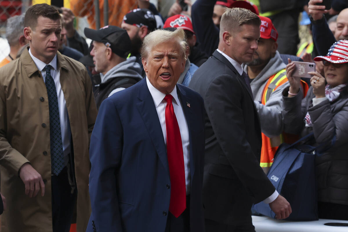 Former President Donald Trump reacts while meeting with construction workers at the constructio ...