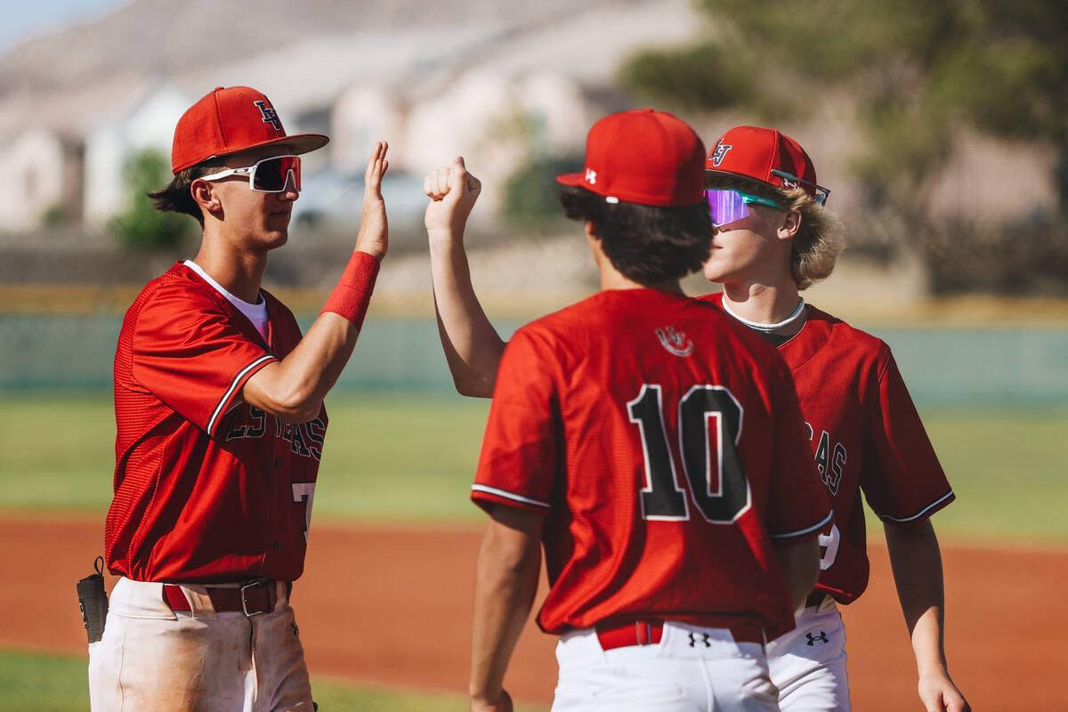Las Vegas teammates high-five after an inning during a high school baseball game between Las Ve ...