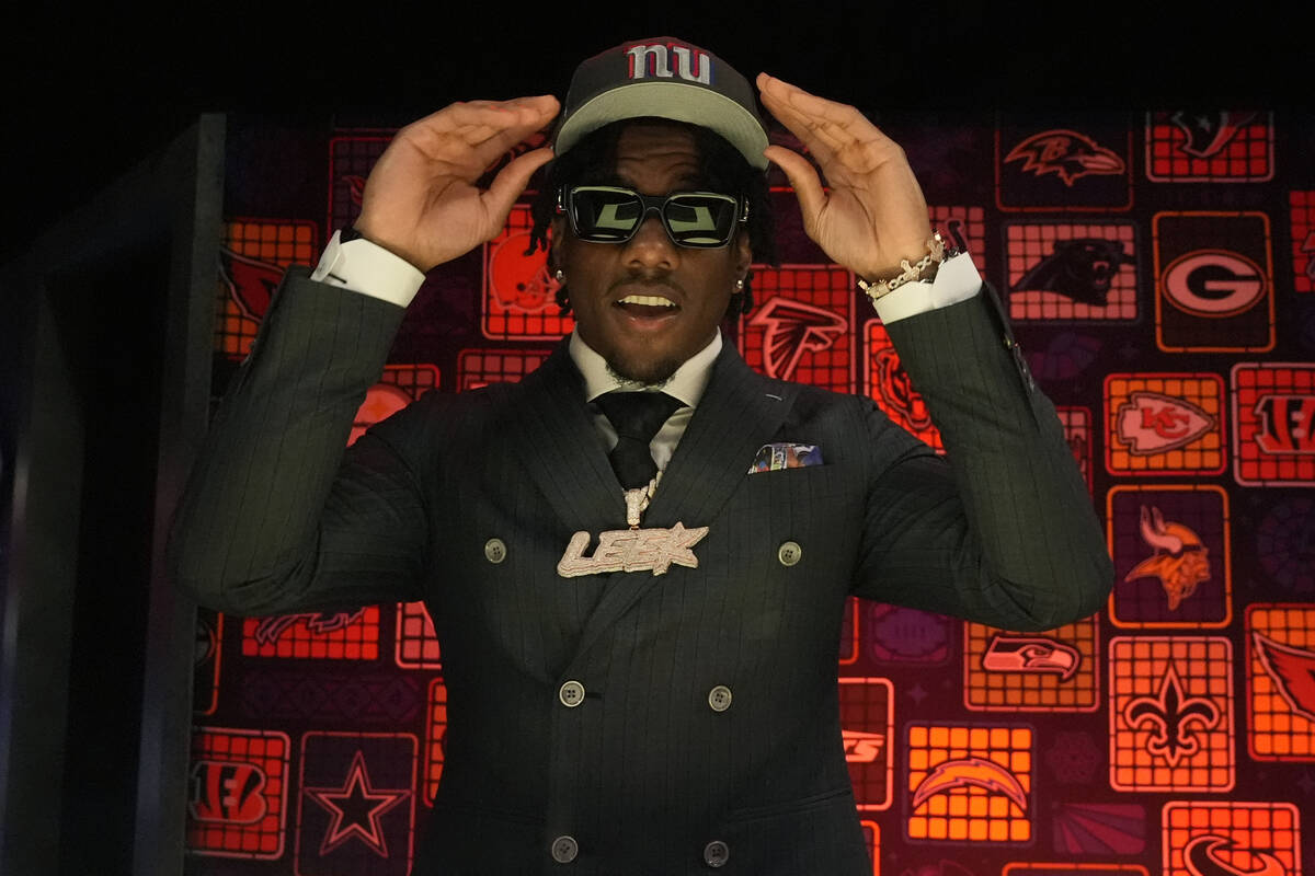 LSU wide receiver Malik Nabers puts on a hat after being chosen by the New York Giants with the ...