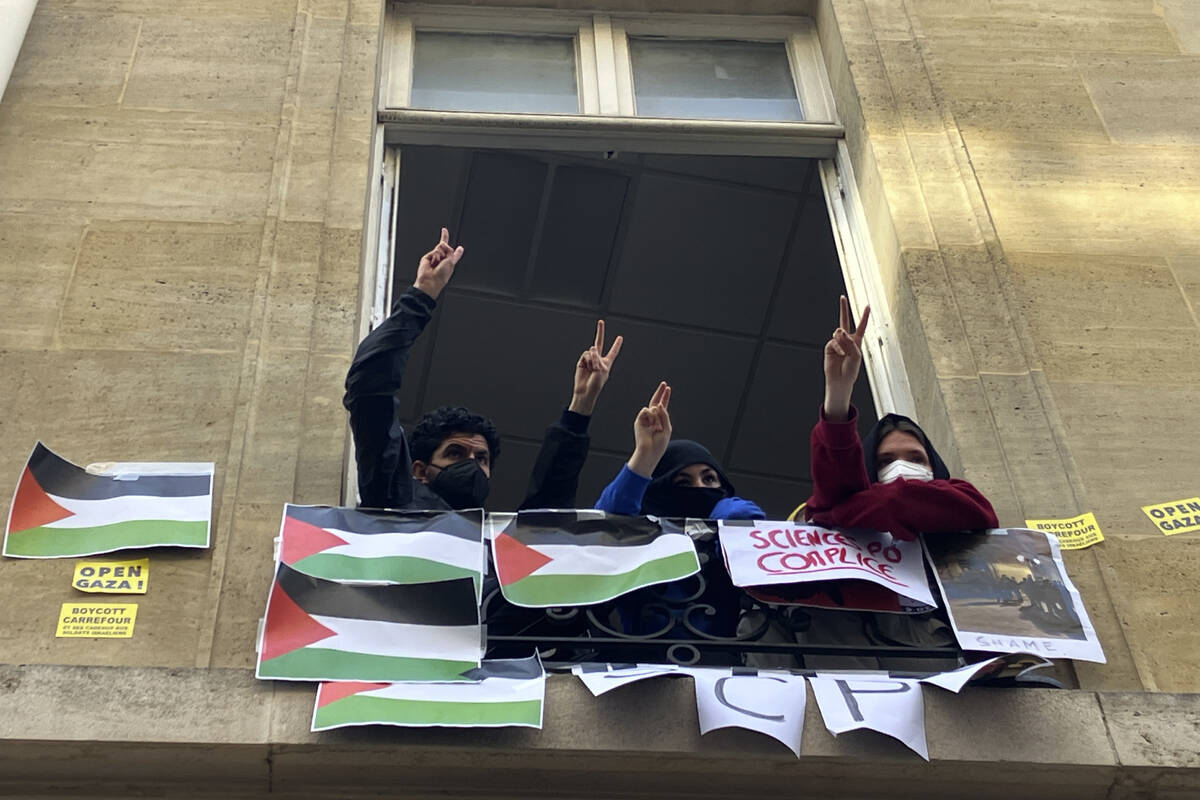 Students blocking the Sciences Po university flash the V sign Friday, April 26, 2024 in Paris. ...