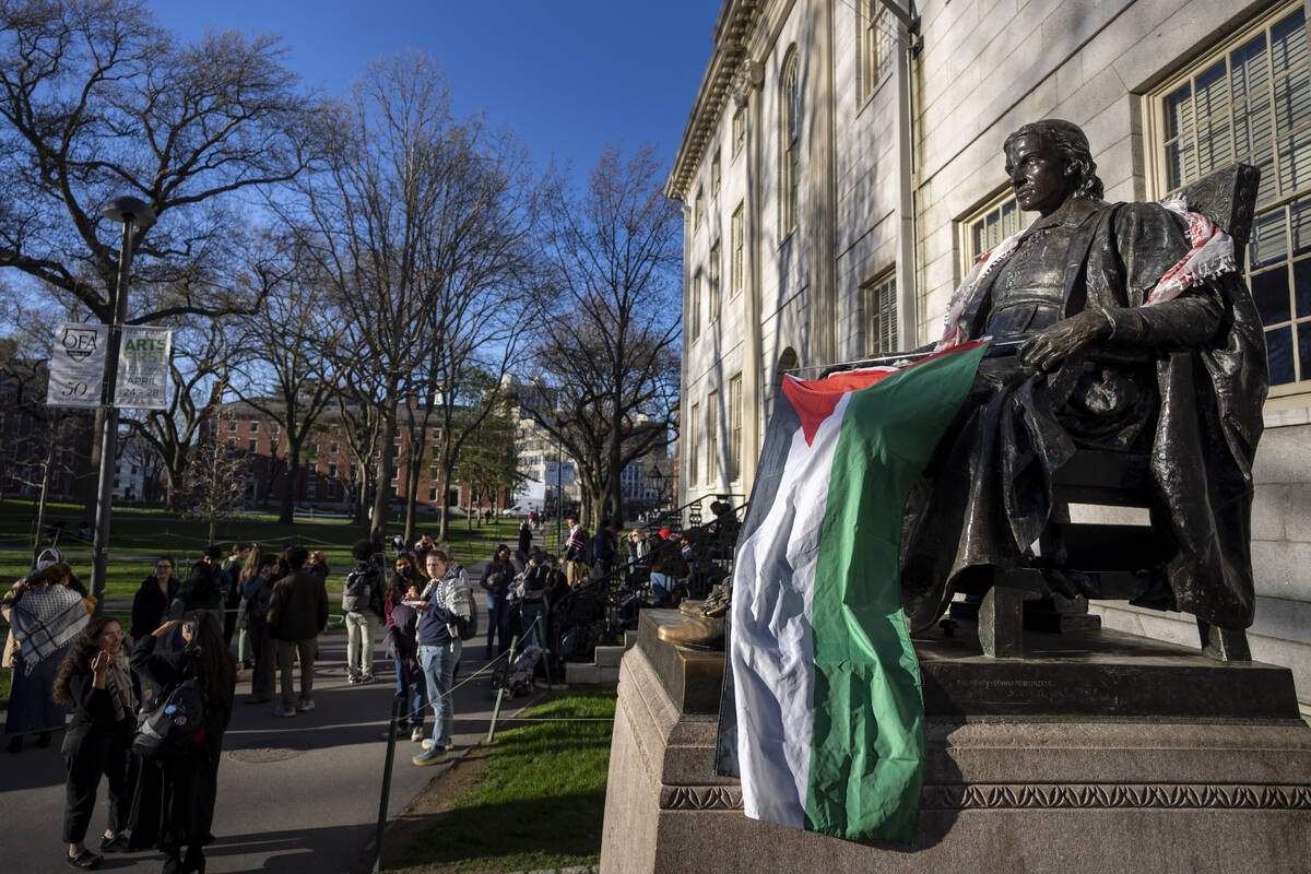 Students protesting against the war in Gaza, and passersby walking through Harvard Yard, are se ...