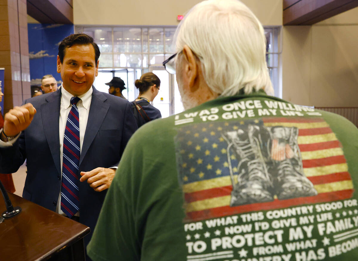 Nevada Secretary of State Francisco Aguilar, left, chats with Phillip Davis, a veteran of the U ...