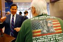 Nevada Secretary of State Francisco Aguilar, left, chats with Phillip Davis, a veteran of the U ...