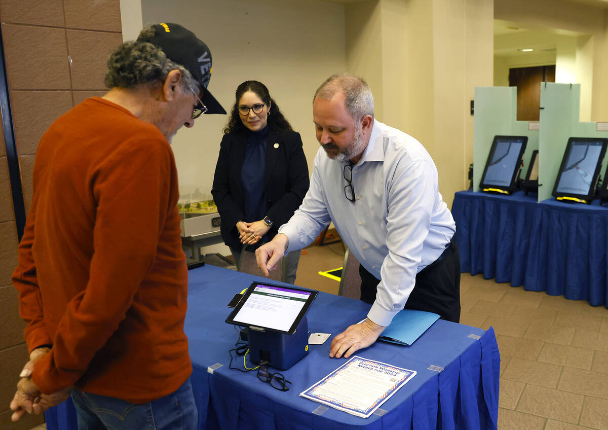 Dan Kulin, right, manager Election Administration, demonstrates how to register at a pooling st ...