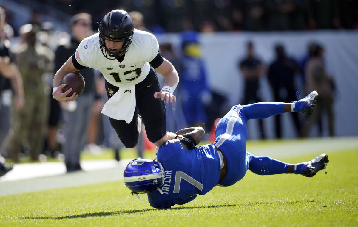 Army quarterback Bryson Daily, left, is tripped up after a short gain by Air Force safety Trey ...