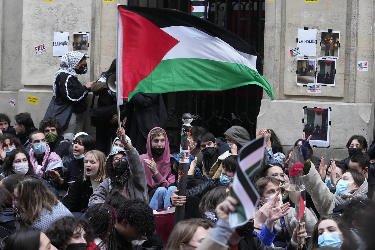 A student wave a palestinian flag outside Sciences-Po university in Paris Friday, April 26, 202 ...
