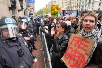 Police in Riot gear stand guard as demonstrators chant slogans outside the Columbia University ...