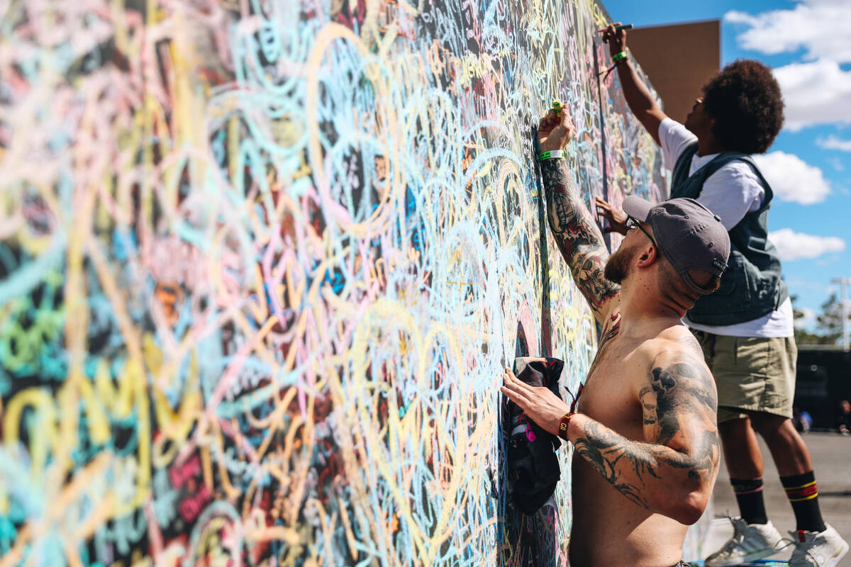 Festival attendees draw on a wall during the Sick New World music festival at the Las Vegas Fes ...