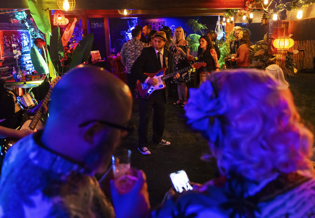 Attendees sip on drinks as Thee Swank Bastards perform during an evening party at a Beverly Gre ...