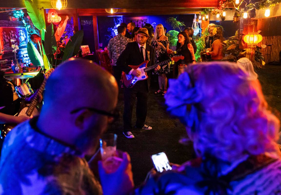 Attendees sip on drinks as Thee Swank Bastards perform during an evening party at a Beverly Gre ...