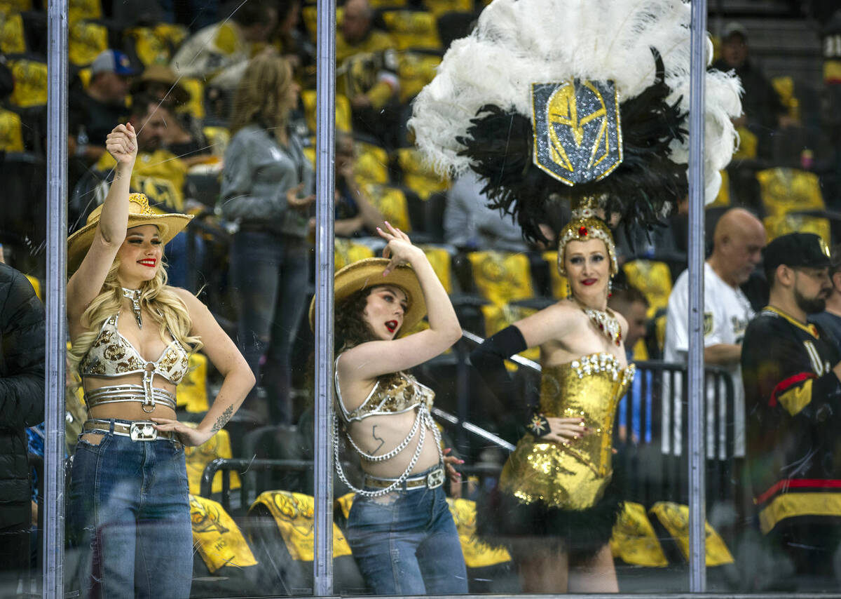 Cowgirls dance as the Dallas Stars get loose with a Golden Belle looking on during warm ups in ...