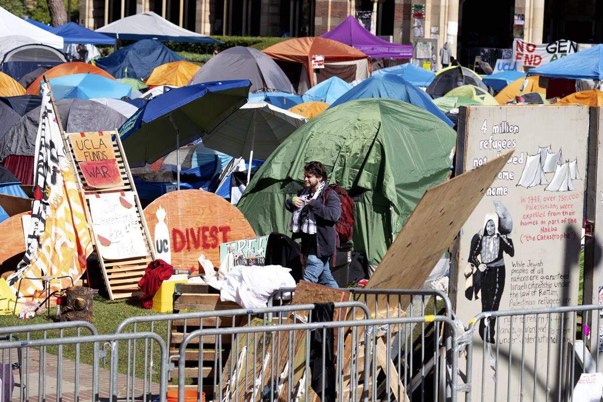 A man passes in front of the pro-Palestinian protesters' tents as they continued to occupy the ...