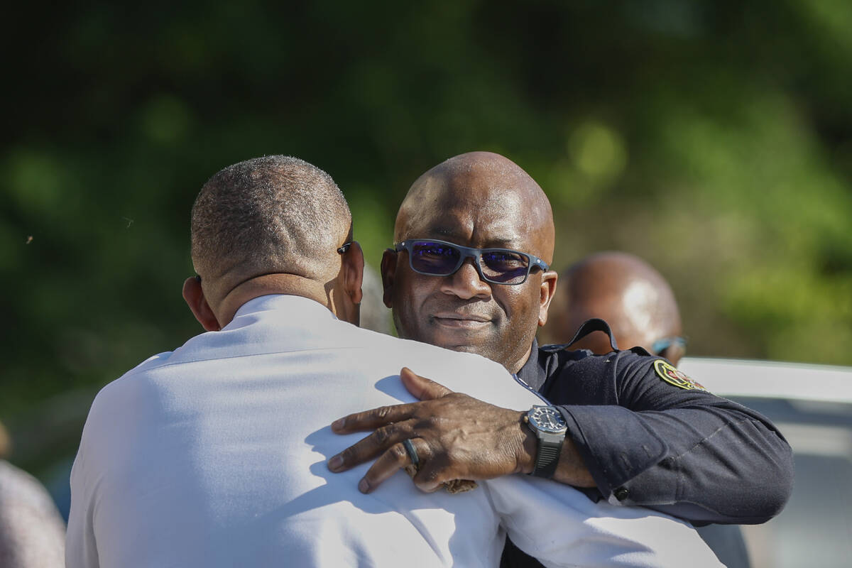 Charlotte Fire Department captain Brian Cunningham, right, hugs Charlotte-Mecklenburg Police Ch ...