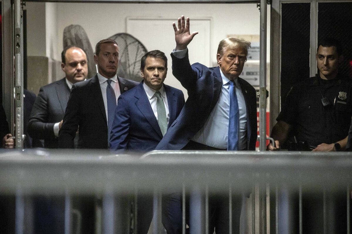 Former President Donald Trump waves to the media as he returns from a break during his trial at ...